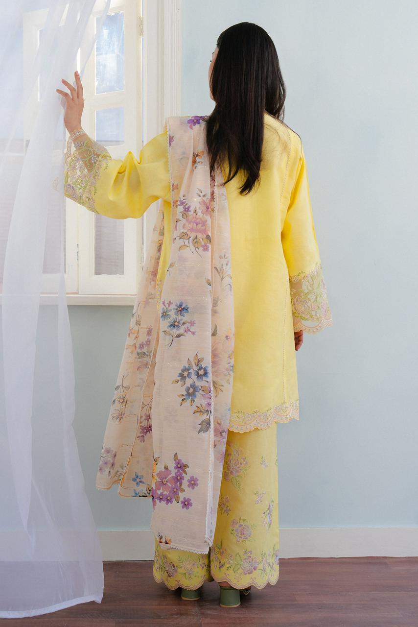 Model wearing COCO yellow embroidered lawn suit from back showing digital printed monar dupatta with floral design"