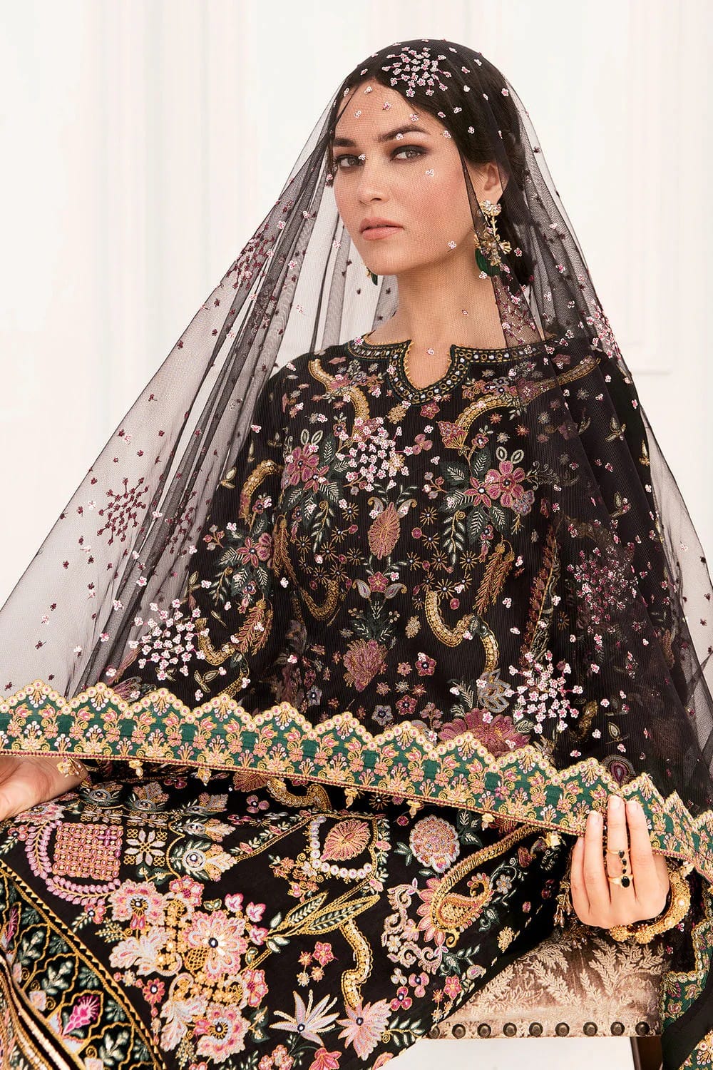 "Bride wearing Baroque black formal suit with heavily embroidered dupatta draped over head"