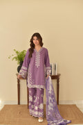 "Model wearing lilac embroidered lawn 3-piece suit with heavy thread work on front, sleeves and daman, holding digital printed voil dupatta"