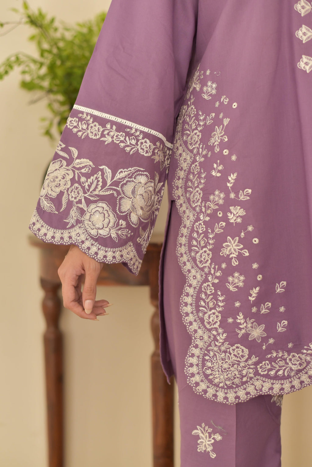 "Close-up of heavy embroidered sleeve with floral thread work and scalloped edge detail on lilac lawn fabric"